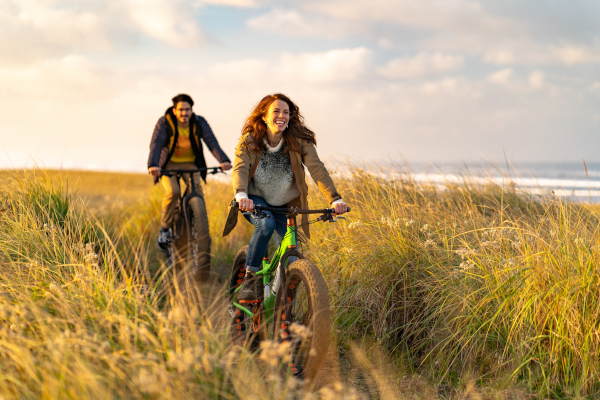 Giovane coppia corre in bici, svolgendo un corretto stile di vita grazie ai benefici degli omega 3