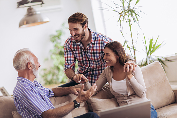 Padre che conversa amabilmente con i figli sui pro e i contro della donazione degli organi sul divano di casa