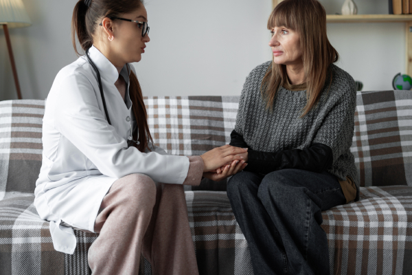 Donna con metastasi al fegato, seduta sul divano, parla con il suo medico