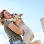 Ragazza in passeggiata felice di tenere in braccio il suo animale domestico, un simpatico e affettuoso cane bulldog