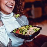 Segretaria in pausa pranzo che mangia un’insalata di tonno, garantendo l’integrazione di Omega 3 e dei suoi benefici attraverso una dieta equilibrata