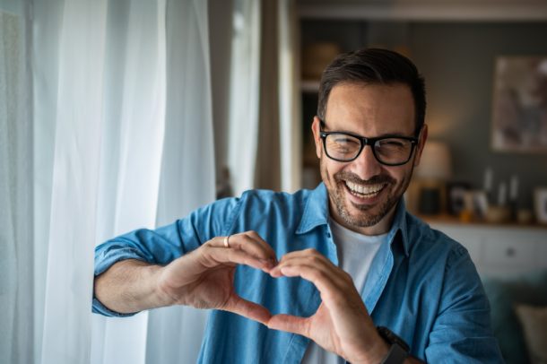 uomo-intervento-coronarografia-fa-segno-cuore Uomo sorride facendo con le mani il segno del cuore dopo intervento coronarografia