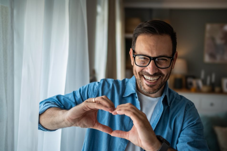 uomo-intervento-coronarografia-fa-segno-cuore Uomo sorride facendo con le mani il segno del cuore dopo intervento coronarografia