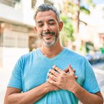 Uomo maturo sorride toccandosi il petto dopo intervento stenosi aortica