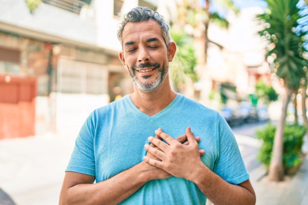 Uomo maturo sorride toccandosi il petto dopo intervento stenosi aortica