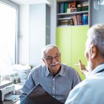 Uomo senior con esenzione per diabete che riceve buone notizie dal suo medico curante durante una visita
