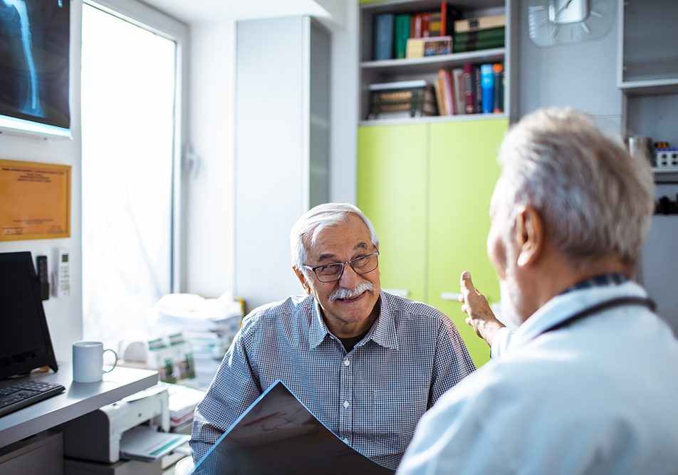 Uomo senior con esenzione per diabete che riceve buone notizie dal suo medico curante durante una visita
