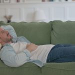 Uomo sdraiato sul suo divano con sintomi pancreatite