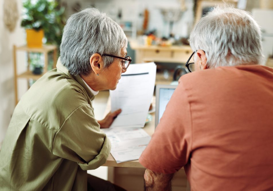 Coppia matura con documentazione per richiedere il rimborso per le spese mediche