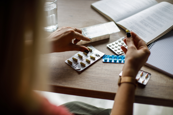 Donna con farmaci, tra le cause che possono aumentare il rischio di cistite emorragica