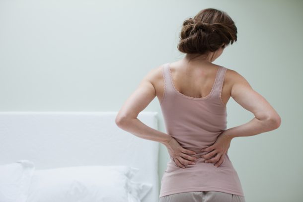 Donna con mal di schiena che potrebbe essere sintomo di tumore