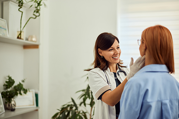 Donna che soffre dei sintomi del nodulo tiroideo consulta medico