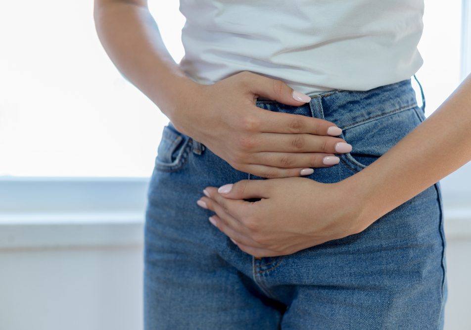 Donna con le mani sul ventre per sintomi tumore alla vescica