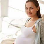Donna incinta fiduciosa mentre si prende cura di sé e delle urine con infezione da Escherichia coli in gravidanza