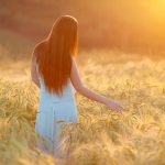 Donna al parco mentre passeggia su un campo di grano inizia ad avvertire i sintomi dell’allergia alle graminacee