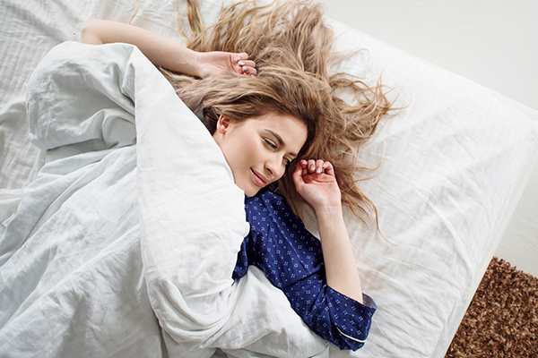 Donna a letto che previene la privazione del sonno svegliandosi da un riposo ristoratore