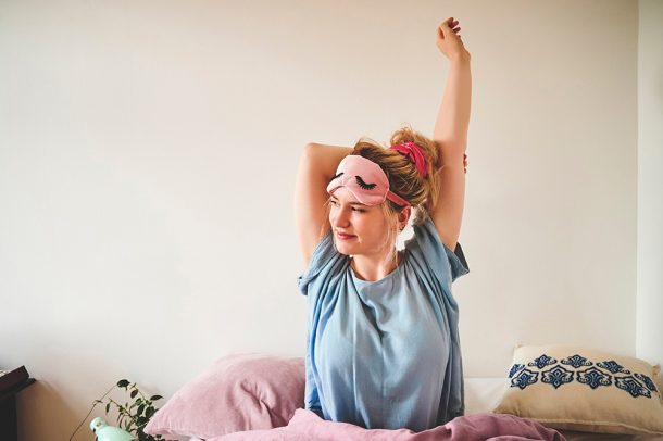 donna-risvegliandosi-in-seguito-a-calcolo-ore-di-sonno Donna che si risveglia riposata ed energica per affrontare una nuova giornata, dopo avere imparato il calcolo delle ore di sonno per i suoi bisogni