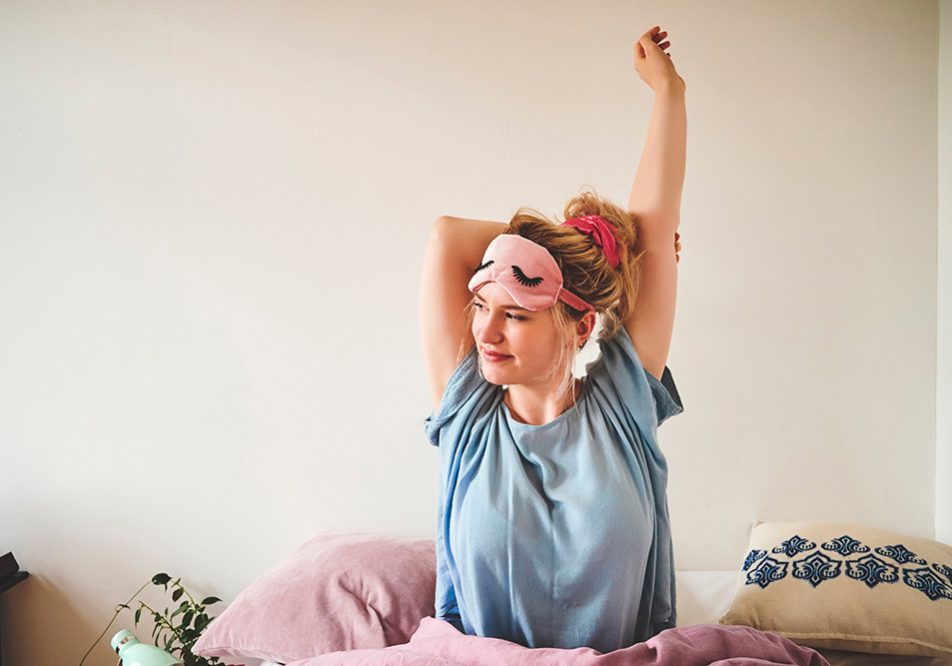 Donna che si risveglia riposata ed energica per affrontare una nuova giornata, dopo avere imparato il calcolo delle ore di sonno per i suoi bisogni