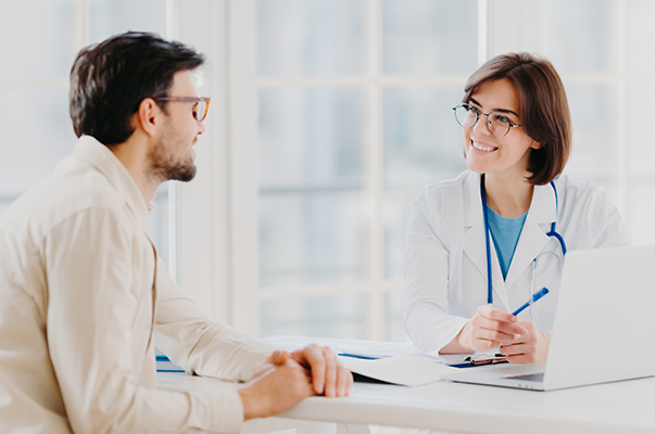 Medico alla scrivania che informa il suo paziente sull’utilizzo della Tachipirina per cervicale e vertigini