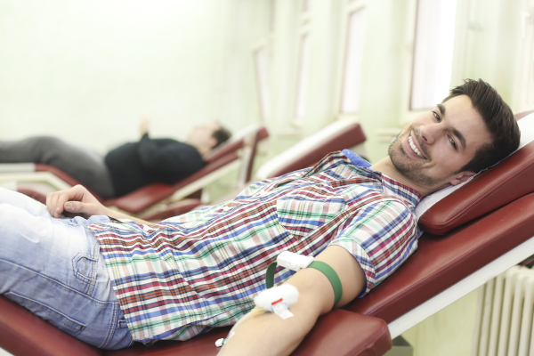 Giovane ragazzo con i requisiti per donazione sangue, sdraiato su un lettino