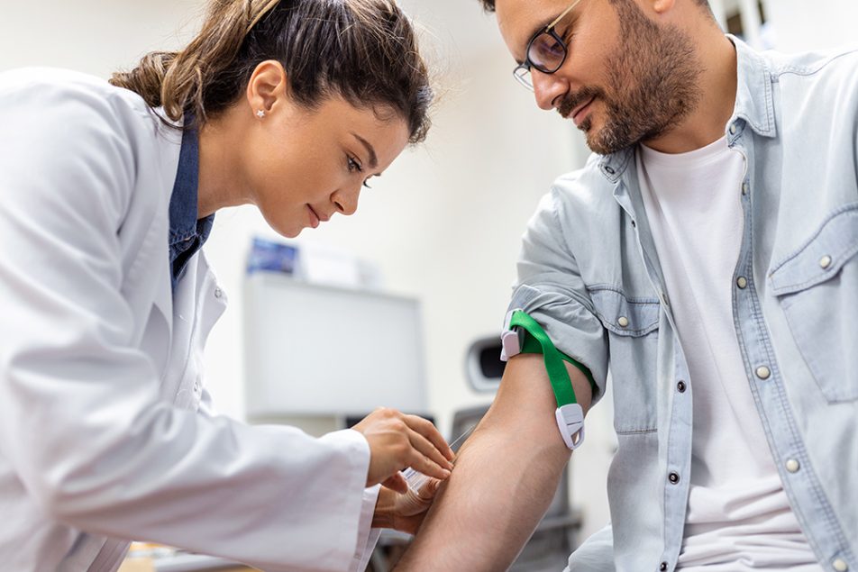 medico-preparando-paziente-a-esame-del-sangue-per-trigliceridi-alti In una sala ospedaliera, la dottoressa prepara il paziente all’esame del sangue per verificare l’eventuale presenza dei trigliceridi alti