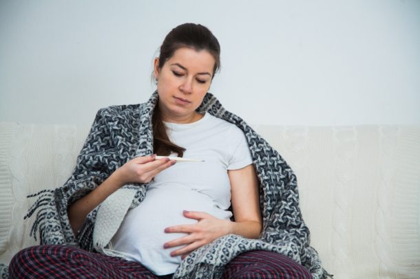 Donna che si misura la febbre per prendere il paracetamolo