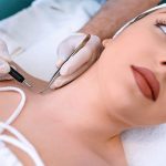 Giovane paziente dal dermatologo che, a causa di un sospetto melanoma, si sottopone a un intervento di asportazione di un neo nella zona delle spalle