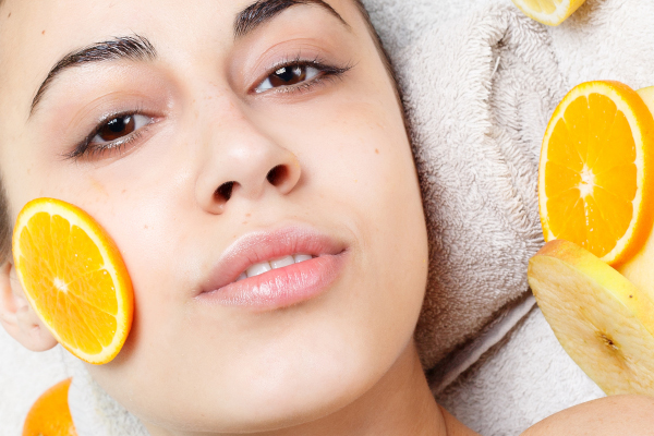 Donna che usa la vitamina c per schiarire le macchie del viso