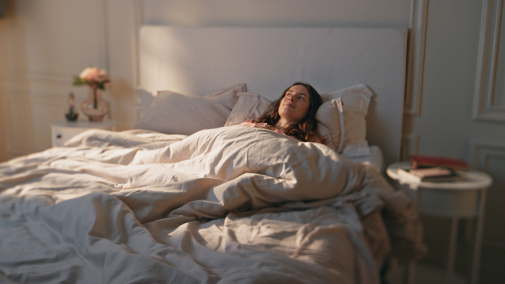 Donna sul suo letto con la testa sollevata per ridurre il reflusso gastroesofageo