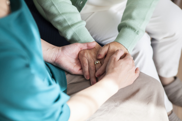Donna tiene le mani e supporta una persona con tumore alla vescica