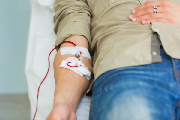 Giovane uomo, che necessita di sangue, sta ricevendo una trasfusione 