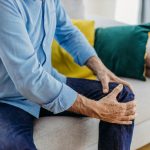 Uomo che soffre di cisti di baker si tocca il ginocchio