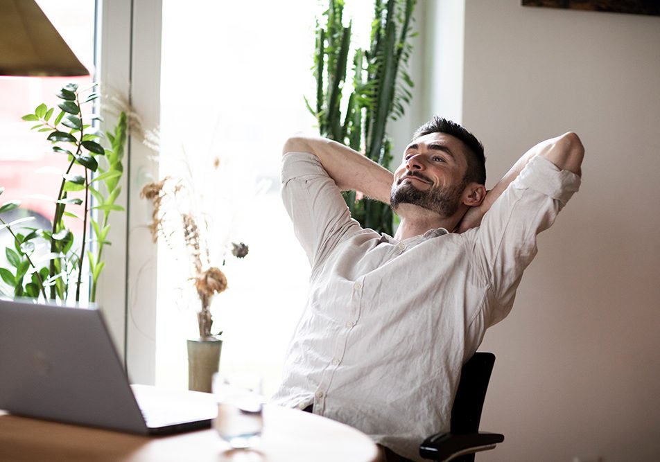 uomo-con-dolore-al-collo-domandandosi-se-tachipirina-per-cervicale-va-bene Uomo seduto al tavolo di casa davanti al laptop, che avverte dolore al collo e si domanda se la Tachipirina va bene per il dolore cervicale