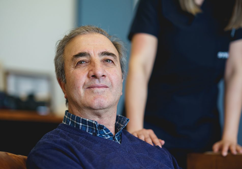 uomo-con-metastasi-presso-clinica-ricevendo-supporto-infermieristico Uomo maturo con metastasi in atto, seduto nella sala d’attesa della clinica medica, che riceve supporto infermieristico