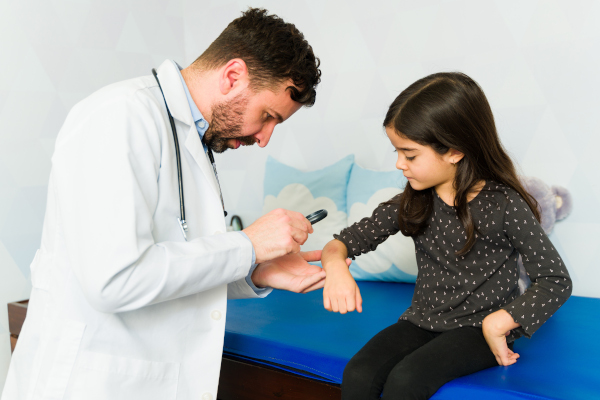 Dermatologo visita giovane paziente per prevenire melanoma