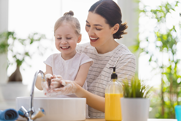 Bambina e giovane madre che si lavano le mani al lavandino per prevenire le infezioni batteriche ed evitare l’utilizzo di farmaci come la cefixima