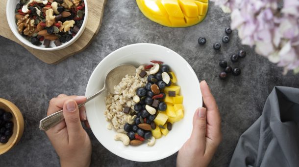 Giovane donna prepara colazione sana con frutta secca