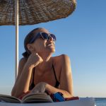 Giovane donna sotto il sole che si informa su come abbronzarsi velocemente