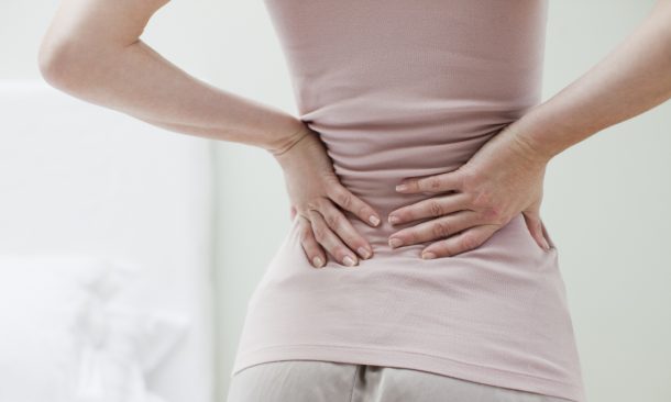 Donna che soffre di cisti di tarlov si tocca la schiena