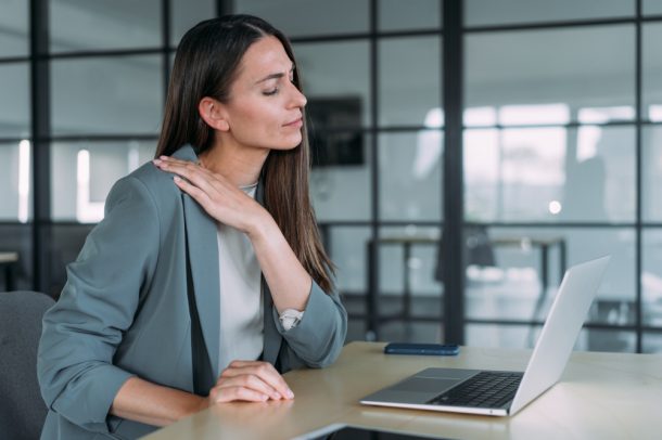 donna-con-sintomi-fisici-ipertensione-emotiva Donna nel suo ufficio che soffre di tensione muscolare, tra i sintomi fisici dell’ipertensione emotiva