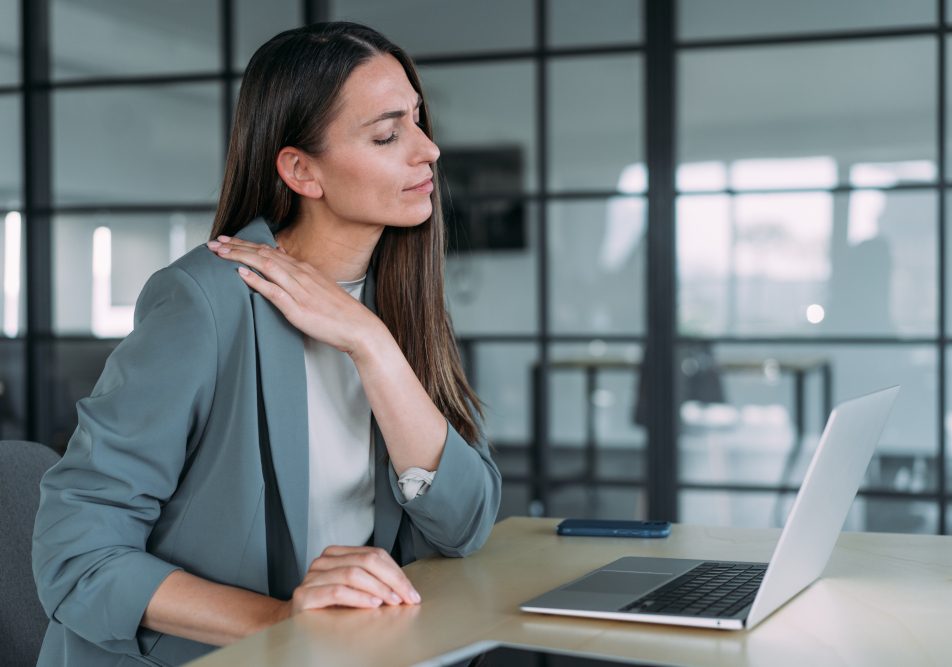 donna-con-sintomi-fisici-ipertensione-emotiva Donna nel suo ufficio che soffre di tensione muscolare, tra i sintomi fisici dell’ipertensione emotiva