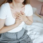 Giovane donna con tubercolosi si porta le mani al petto