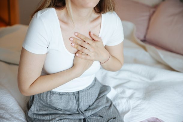 Giovane donna con tubercolosi si porta le mani al petto