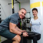 Donna disabile in palestra che sia allena per le competizioni paralimpiche grazie al supporto del suo allenatore di fiducia