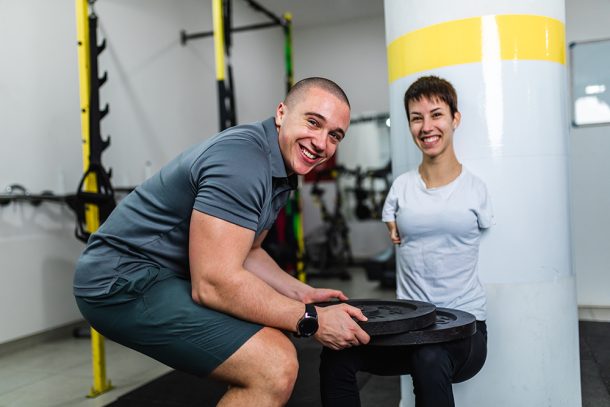 Donna disabile in palestra che sia allena per le competizioni paralimpiche grazie al supporto del suo allenatore di fiducia