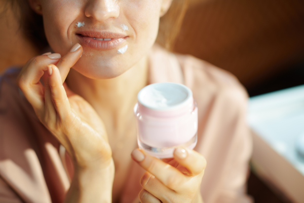 Giovane donna idrata la pelle del viso per prevenire la dermatite da contatto