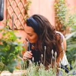 Donna nel cortile di casa che raccoglie ingredienti per produrre ansiolitici naturali senza la necessità della ricetta medica