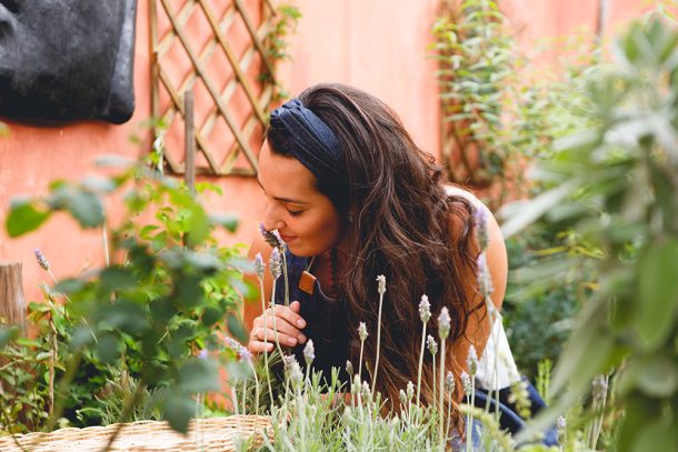 Donna nel cortile di casa che raccoglie ingredienti per produrre ansiolitici naturali senza la necessità della ricetta medica
