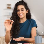 Donna in una cucina mansardata che si domanda se assumere la compressa di ottatropina prima o dopo i pasti, ricordandosi l’indicazione del medico