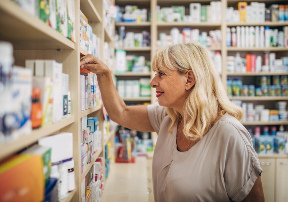 donna-in-farmacia-per-acquistare-farmaci-senza-ricetta Donna matura tra gli scaffali di una farmacia per acquistare farmaci senza ricetta
